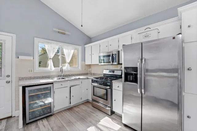 a kitchen with stainless steel appliances granite countertop a stove a refrigerator and a sink