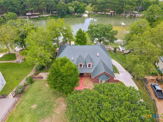an aerial view of a house with a garden and lake view
