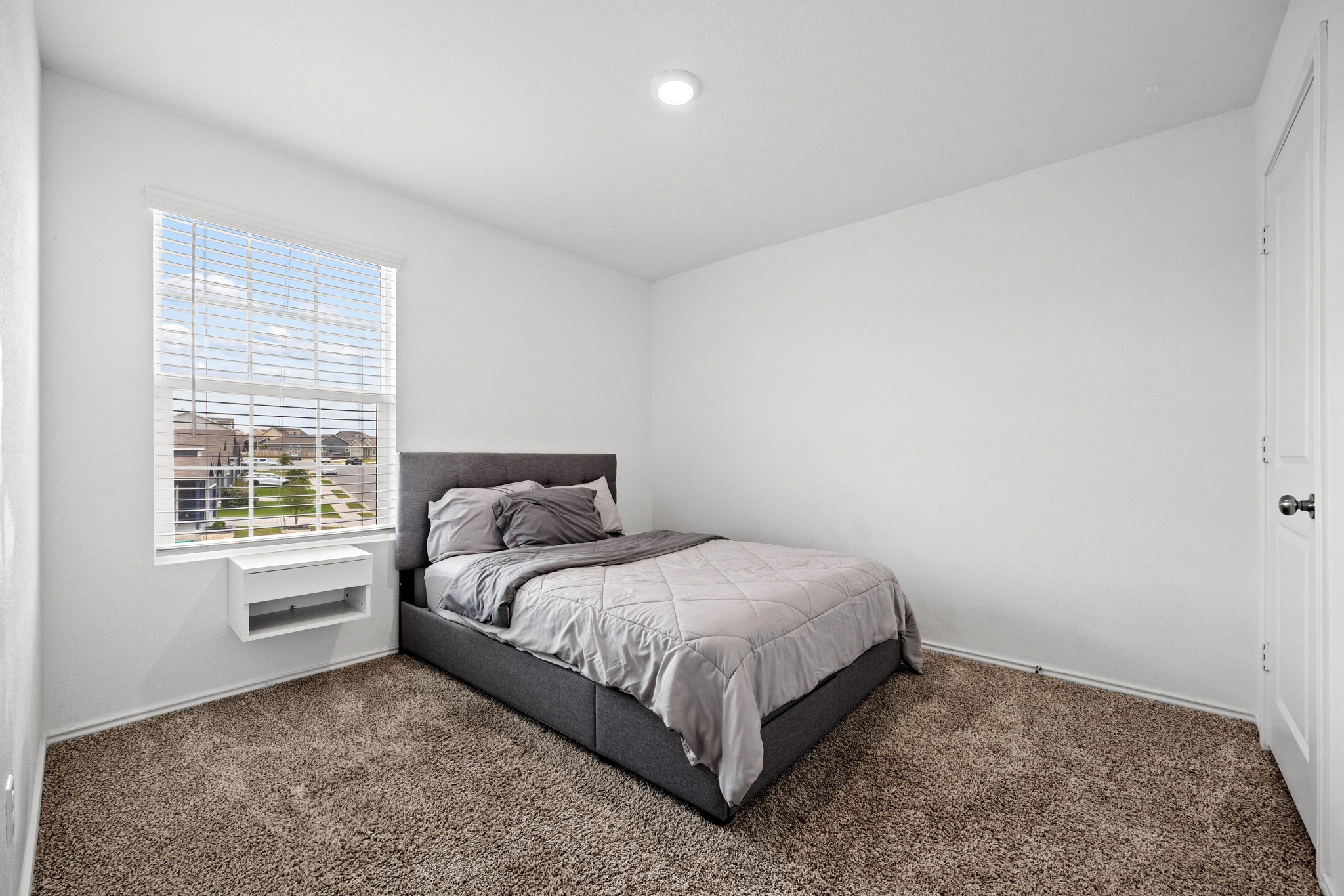 14121 Berning Road Manor, TX 78653 - Photo 18 of 27 A well-lit bedroom provides comfortable living with plush carpeting and natural illumination from a wide window.