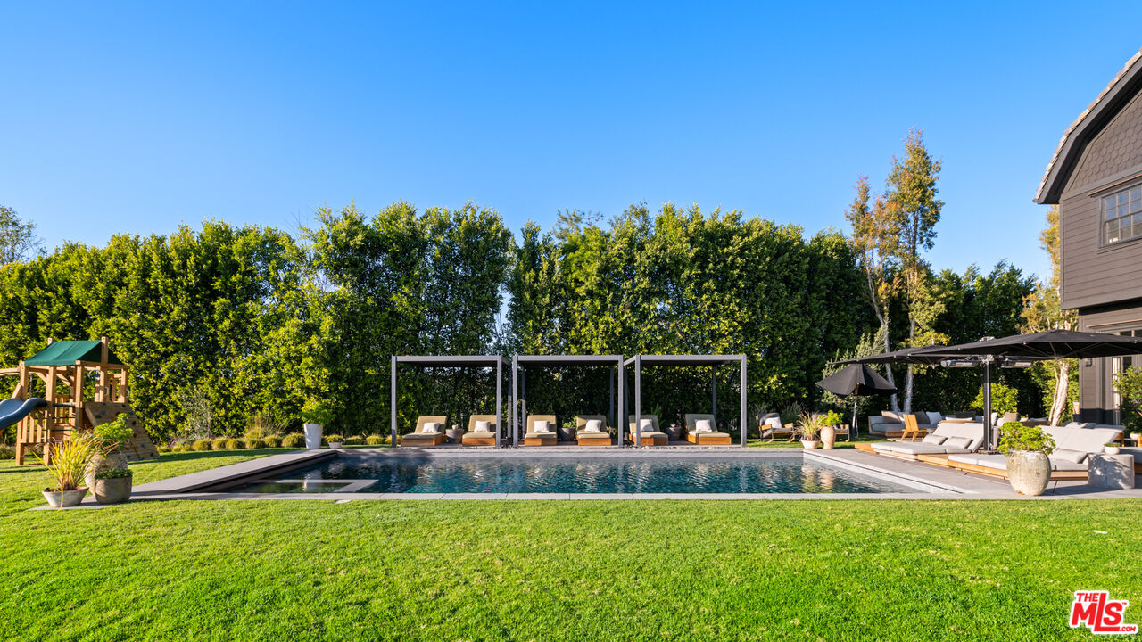 a view of house with swimming pool and sitting area