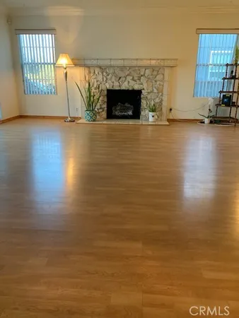 a view of a livingroom with wooden floor and a fireplace