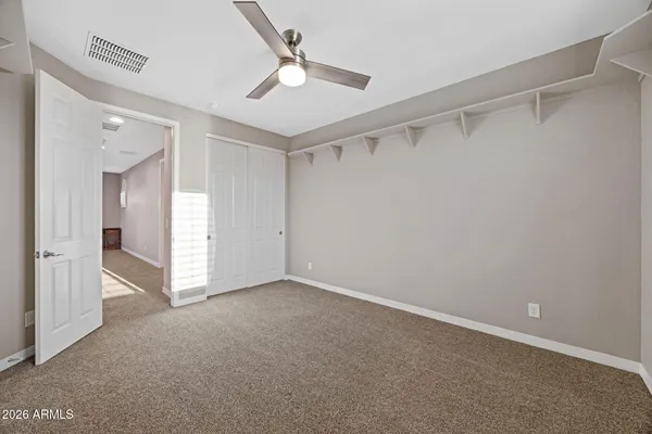 a walk in closet with wooden floor