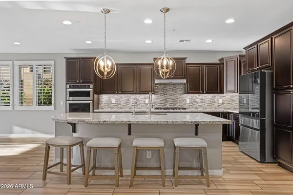 a kitchen with kitchen island granite countertop a sink cabinets and stainless steel appliances