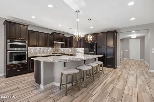 a large kitchen with granite countertop a large counter top stainless steel appliances and cabinets