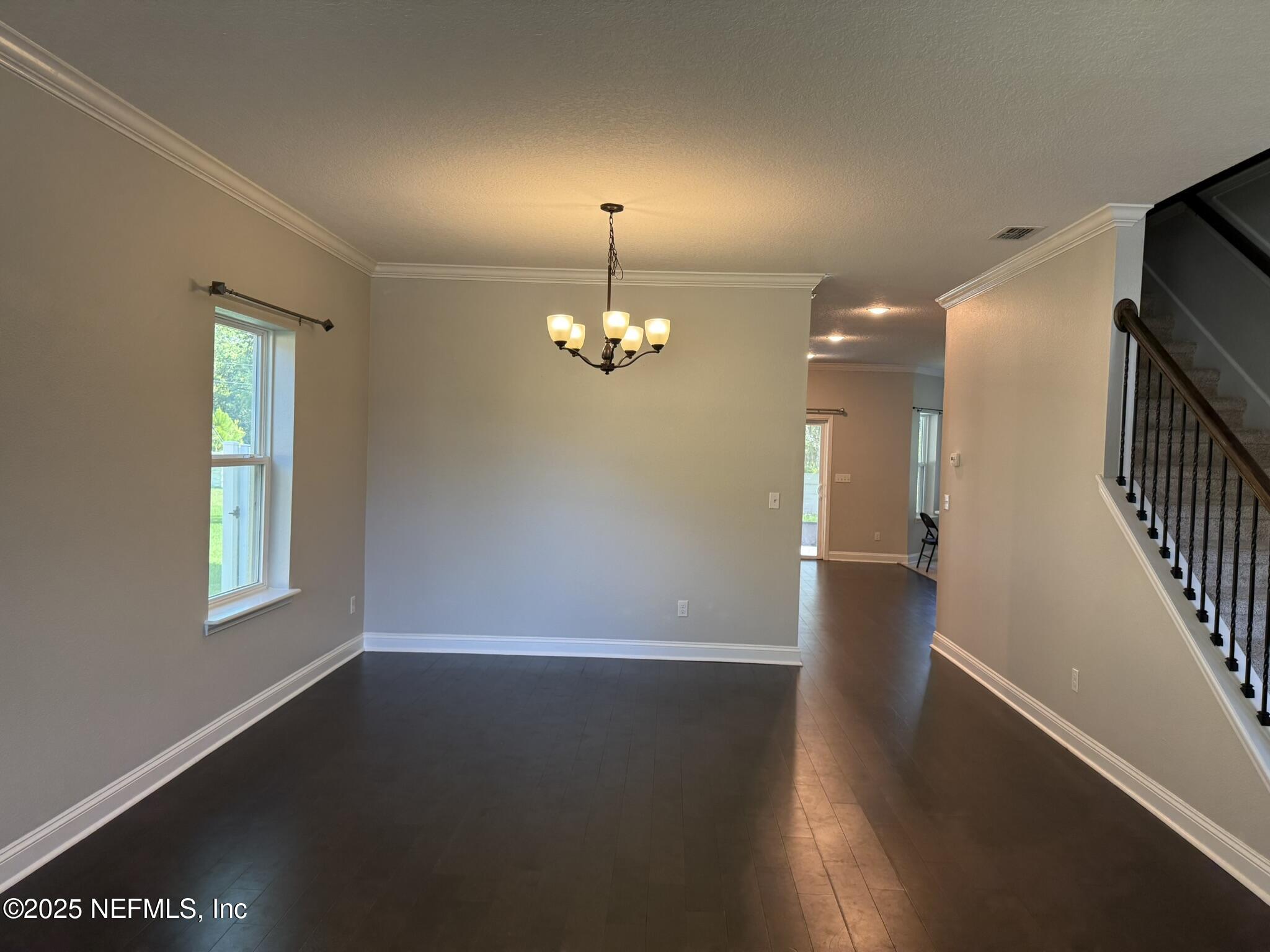 12198 Ridge Crossing Way Jacksonville, FL 32226 - Photo 3 of 28 an empty room with wooden floor chandelier and windows