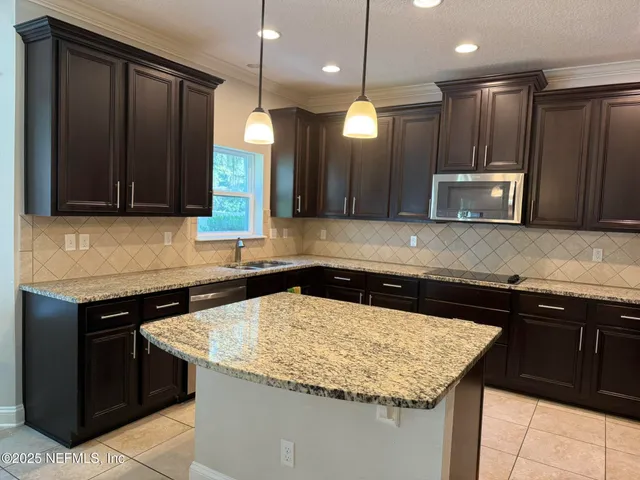 a kitchen with a stove a sink and a microwave