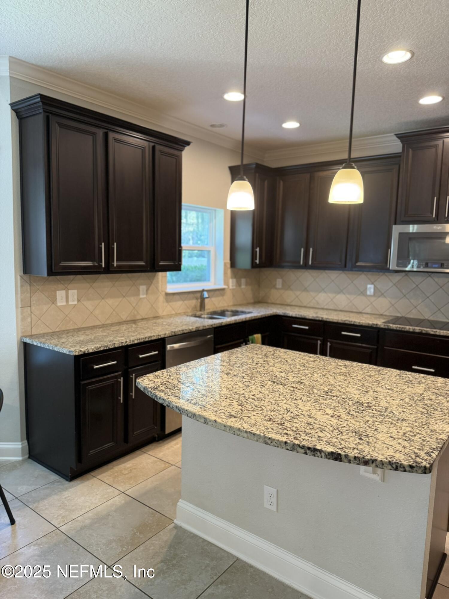 12198 Ridge Crossing Way Jacksonville, FL 32226 - Photo 9 of 28 a kitchen with a stove a sink and a microwave