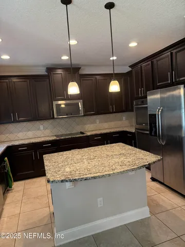 a kitchen with a sink a counter space appliances and cabinets
