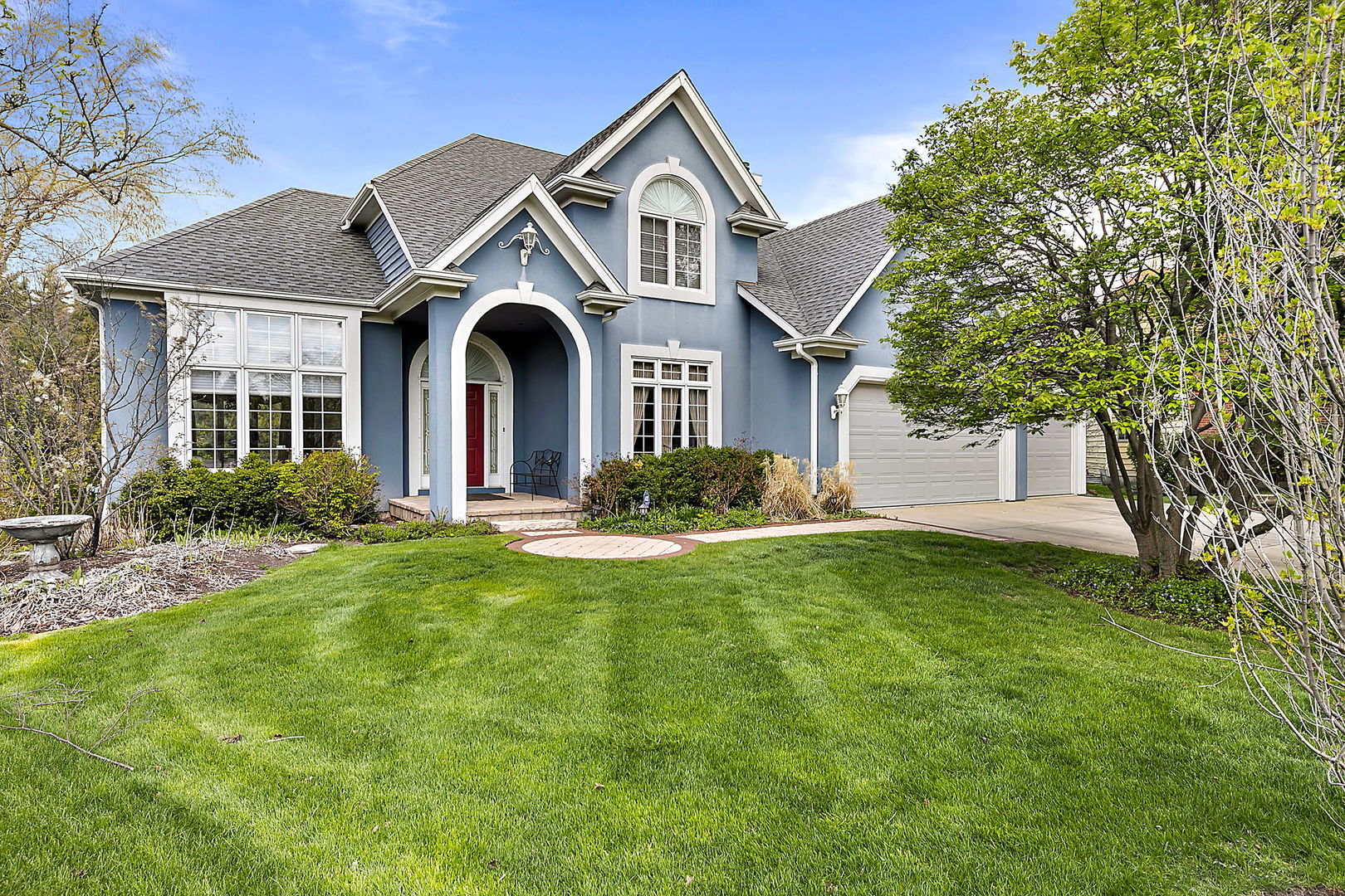 a front view of a house with yard and green space