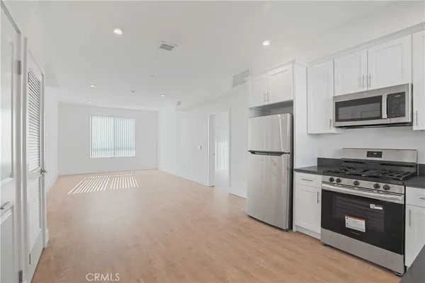 a view of a kitchen with a sink and a refrigerator