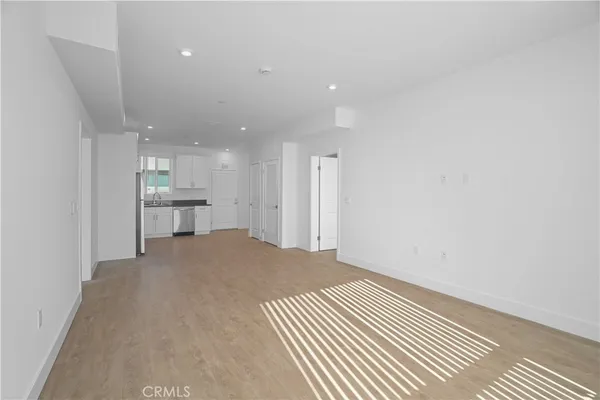 a walk in closet with wooden floor