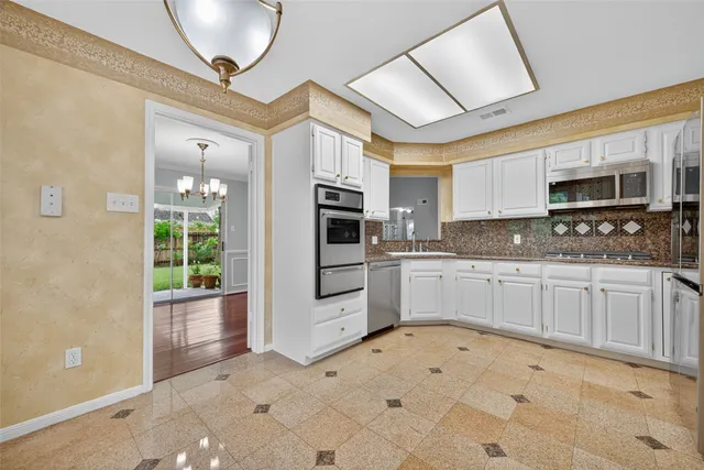 a kitchen with granite countertop a stove a sink and a microwave