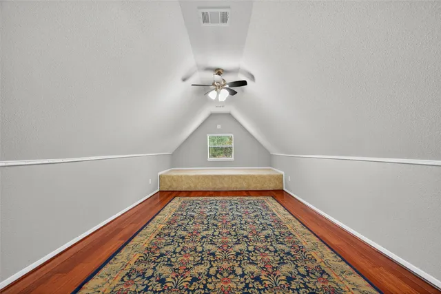 an empty room with windows and ceiling fan