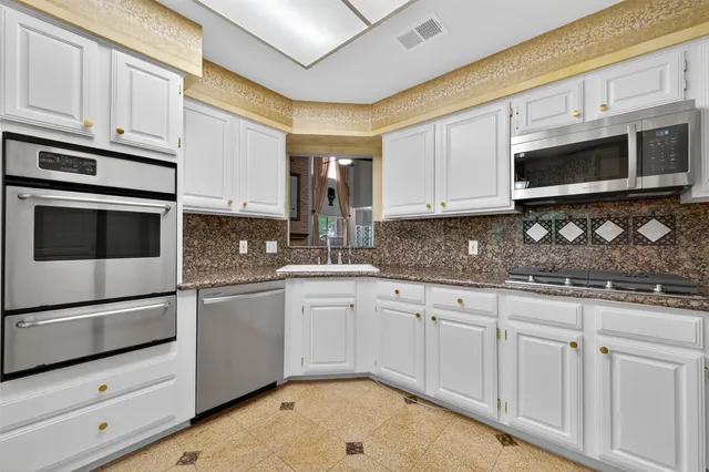 a kitchen with stainless steel appliances granite countertop a sink and a stove