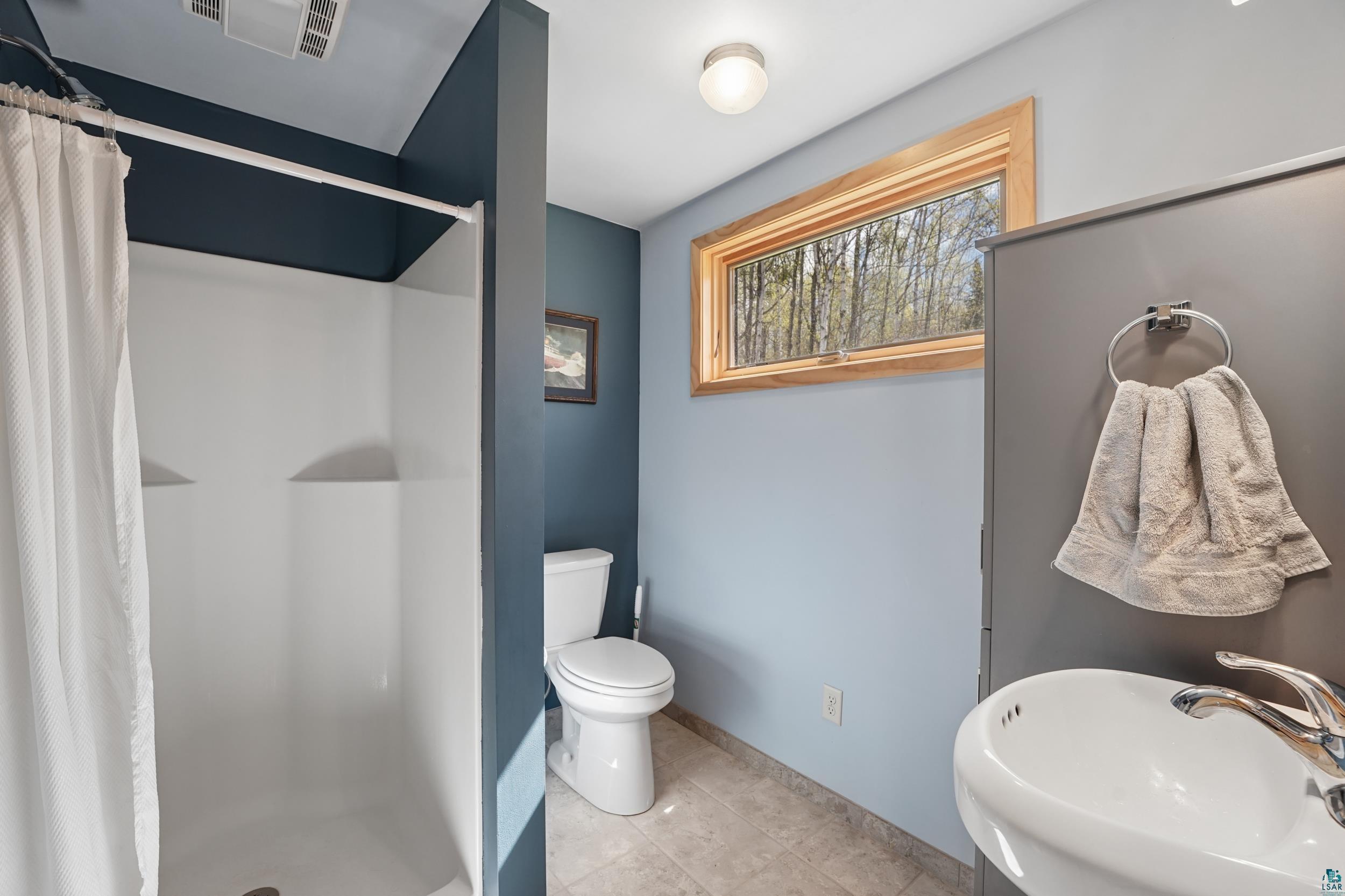 89095 West Romans Point Road Herbster, WI 54844 - Photo 20 of 30 Bathroom featuring a walk-in shower with white surround, single toilet, and pedestal sink with chrome faucet