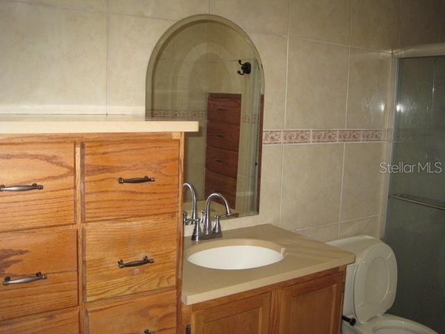 5415 Rutland Court Orlando, FL 32812 - Photo 14 of 25 a bathroom with a granite countertop sink a toilet and a mirror