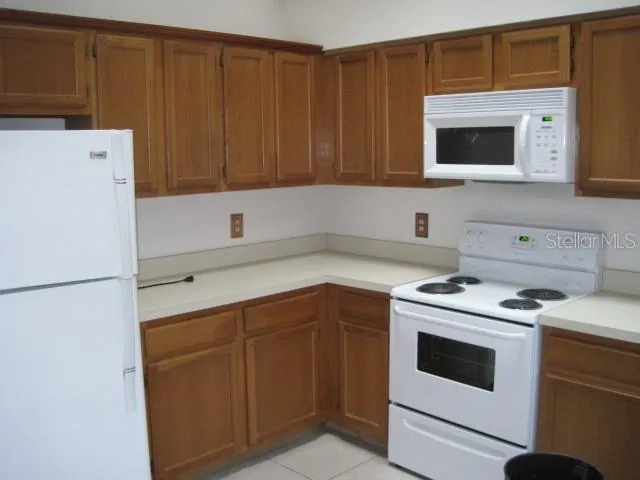 a kitchen with a cabinets and white appliances