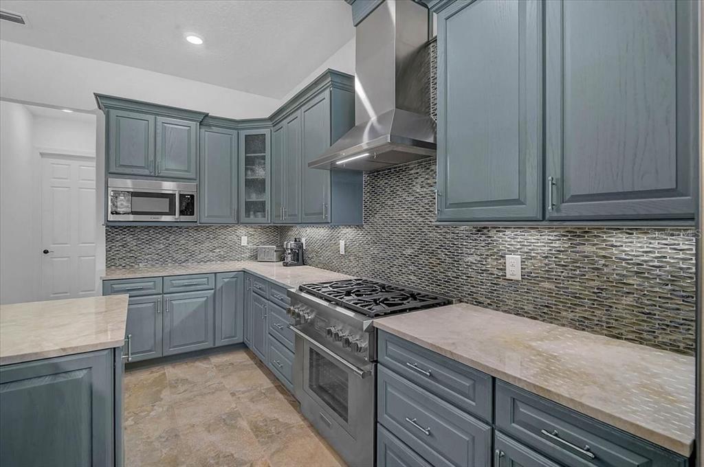 113 Burney Road Osprey, FL 34229 - Photo 12 of 42 a kitchen with stainless steel appliances granite countertop a sink stove and cabinets