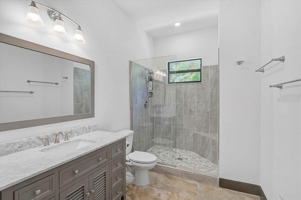 113 Burney Road Osprey, FL 34229 - Photo 26 of 42 a bathroom with a shower sink vanity mirror and toilet