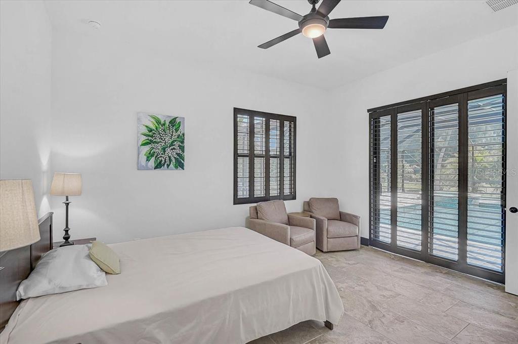 113 Burney Road Osprey, FL 34229 - Photo 28 of 42 a bedroom with a bed and a chandelier