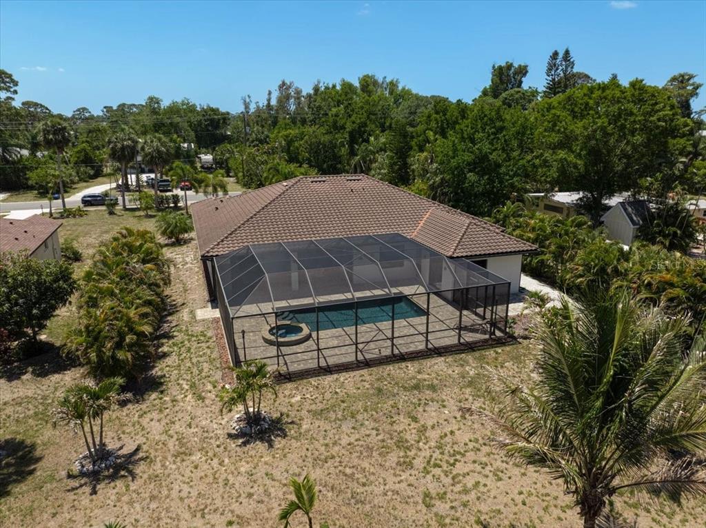 113 Burney Road Osprey, FL 34229 - Photo 39 of 42 a view of a white house with a yard and hanging chair