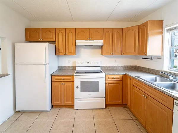 a kitchen with a cabinets and white appliances