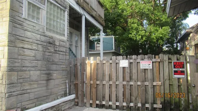 a view of a wooden door and a tree in front of house