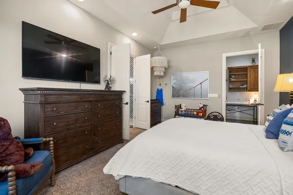 a bed room with a bed a flat screen tv and a dresser