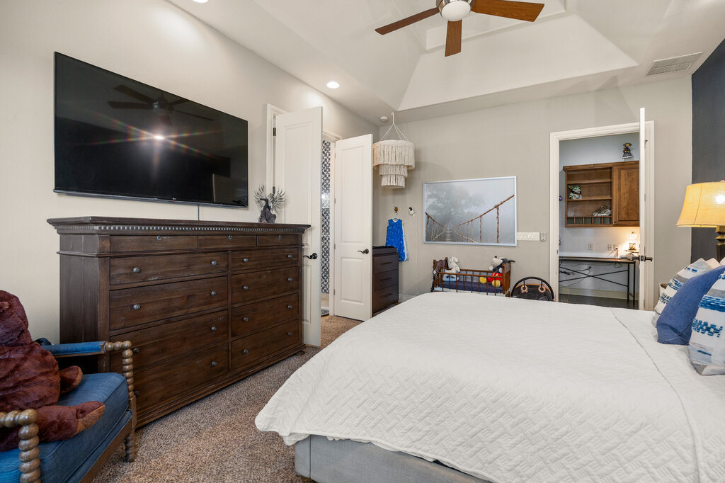 22226 Rivolta Lane San Antonio, TX 78257 - Photo 16 of 24 a bed room with a bed a flat screen tv and a dresser