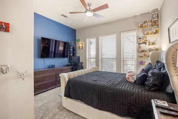 a bedroom with a bed and a flat tv screen on dresser