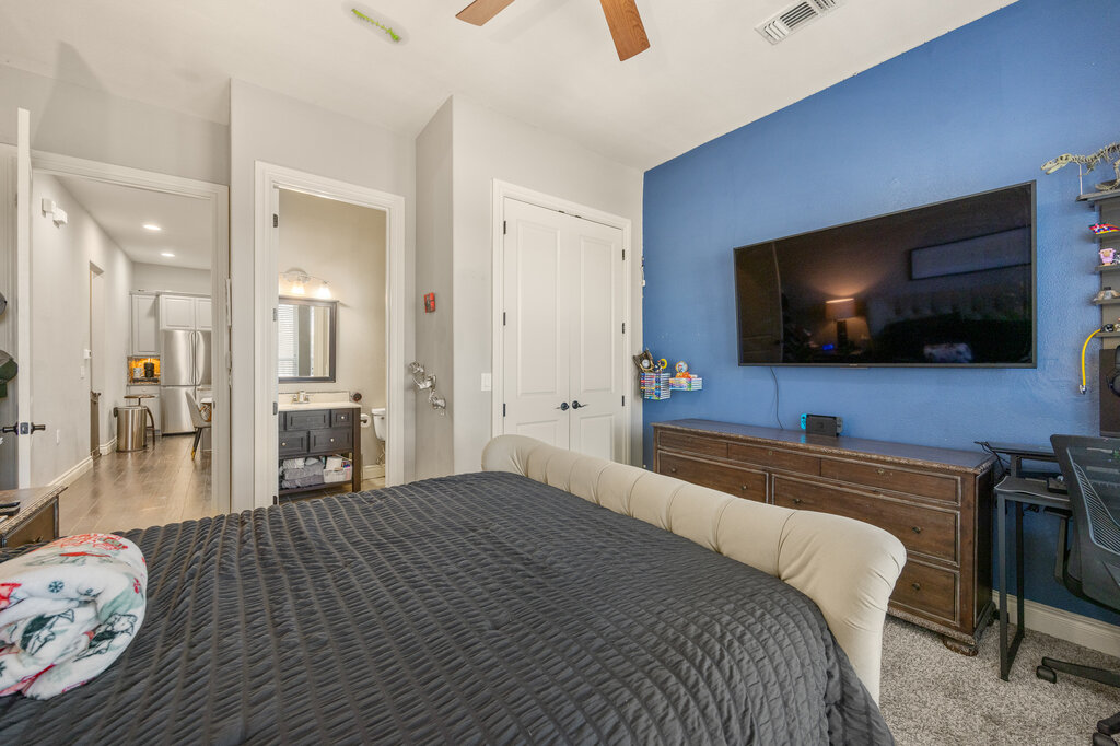 22226 Rivolta Lane San Antonio, TX 78257 - Photo 21 of 24 a bedroom with a bed and a flat screen tv