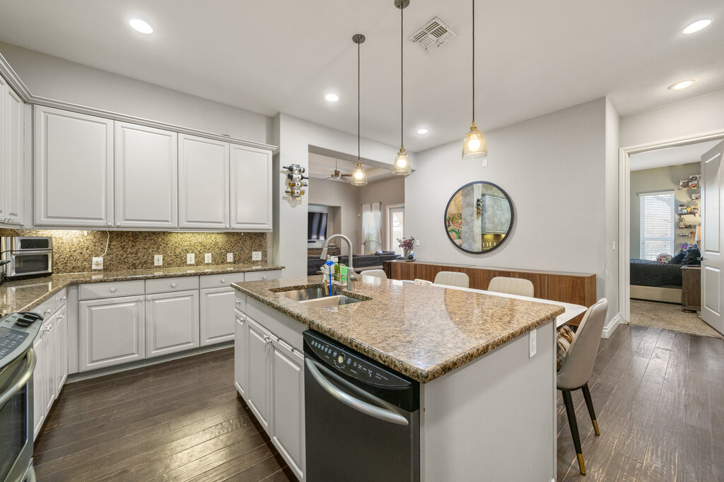 22226 Rivolta Lane San Antonio, TX 78257 - Photo 23 of 24 a kitchen with a stove a sink a kitchen island with wooden cabinets and floor