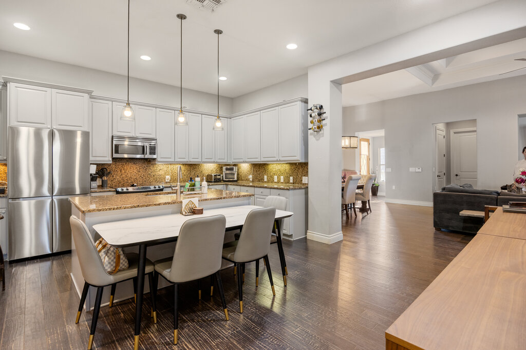 22226 Rivolta Lane San Antonio, TX 78257 - Photo 3 of 24 a kitchen with stainless steel appliances a dining table chairs refrigerator and microwave
