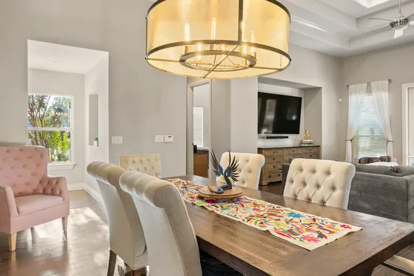 a living room with furniture a flat screen tv and a chandelier