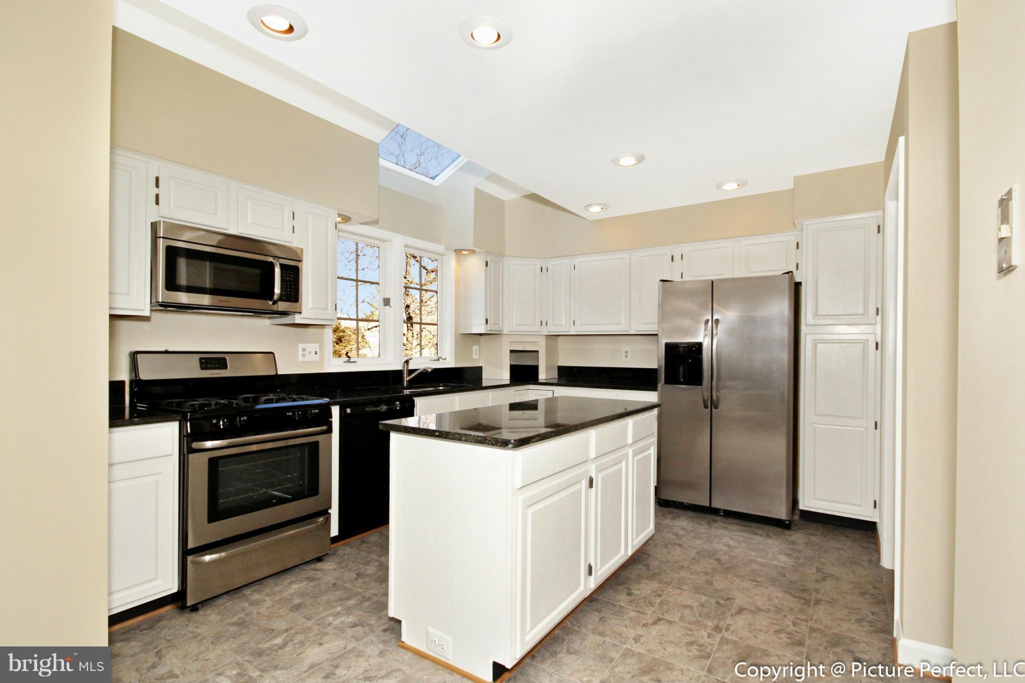 19111 Munger Farm Road Poolesville, MD 20837 - Photo 15 of 30 a kitchen with stainless steel appliances granite countertop a stove top oven a sink a refrigerator and a microwave