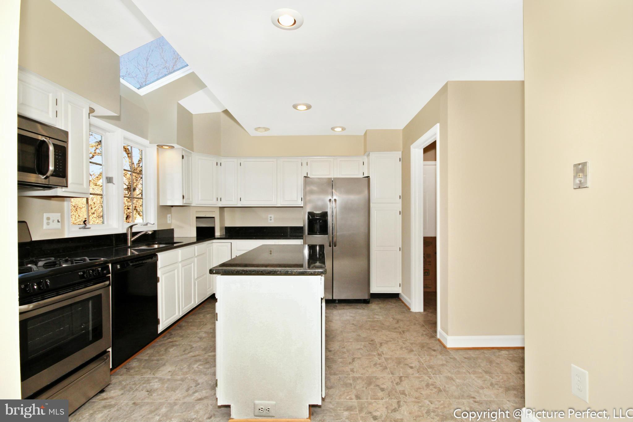 19111 Munger Farm Road Poolesville, MD 20837 - Photo 16 of 30 a kitchen with a refrigerator a stove top oven and white cabinets