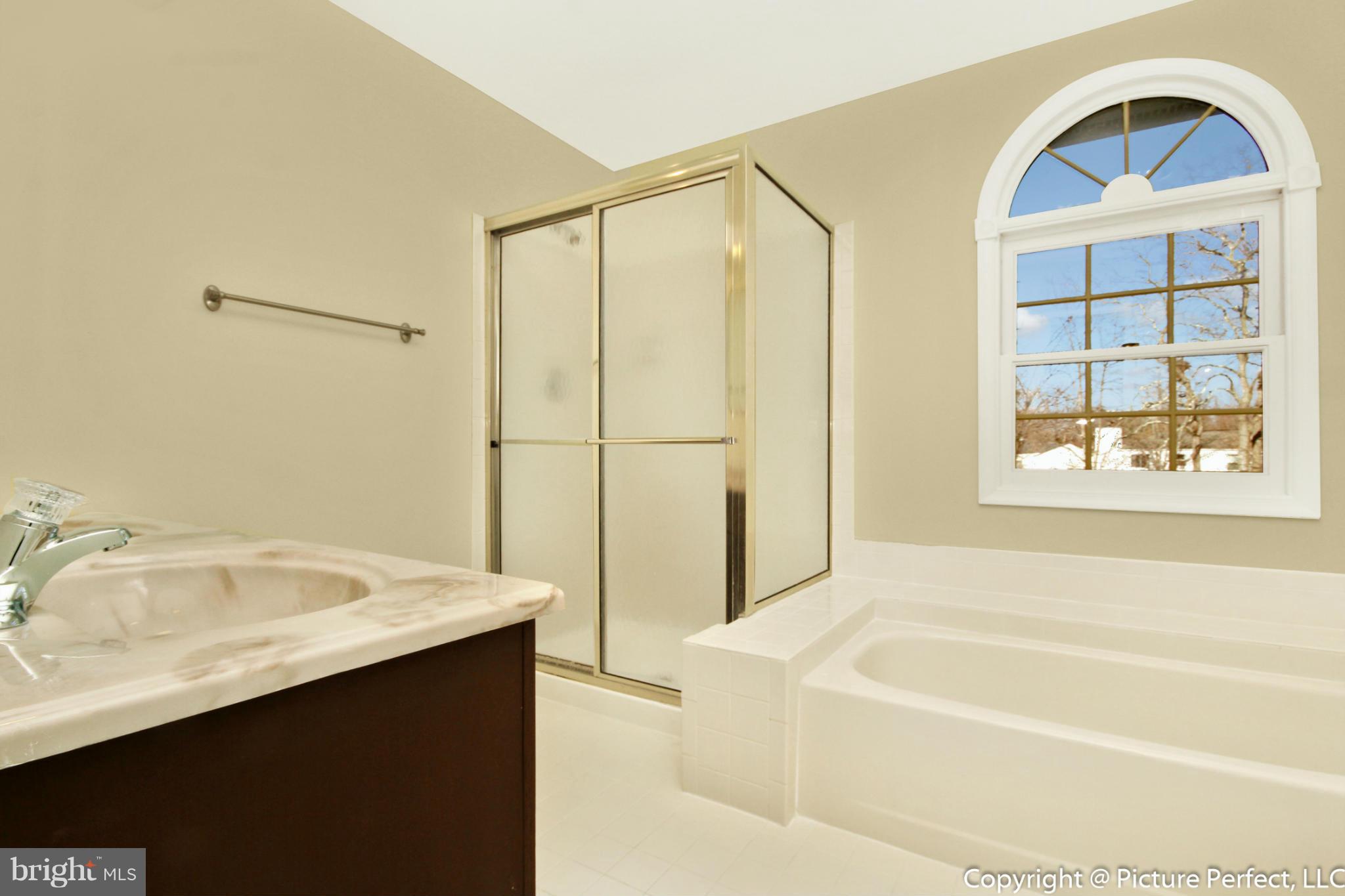 19111 Munger Farm Road Poolesville, MD 20837 - Photo 20 of 30 a bathroom with a sink a bathtub and a shower