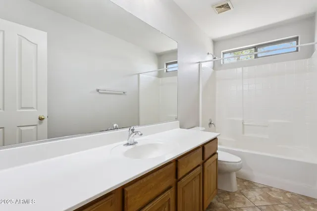 a bathroom with a granite countertop sink a toilet and shower