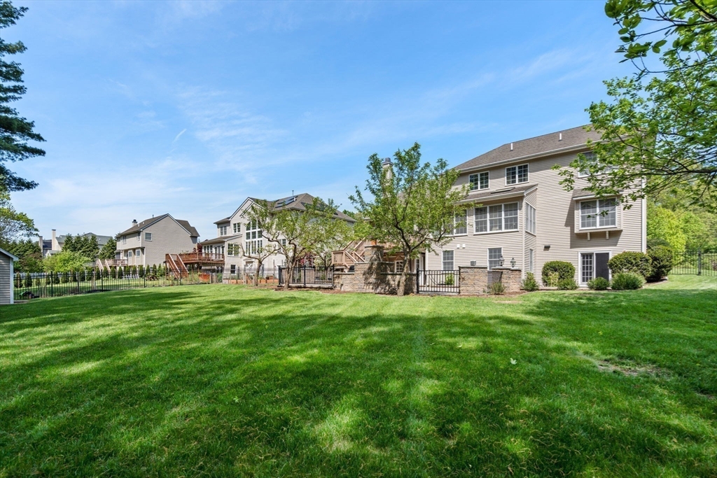 34 Hound Pack Circle Walpole, MA 02032 - Photo 35 of 40 a view of a white house in front of a big yard with plants and large trees