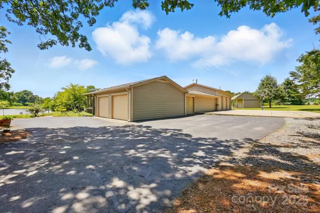 a kitchen with kitchen island granite countertop stainless steel appliances a sink a stove a refrigerator cabinets and a window