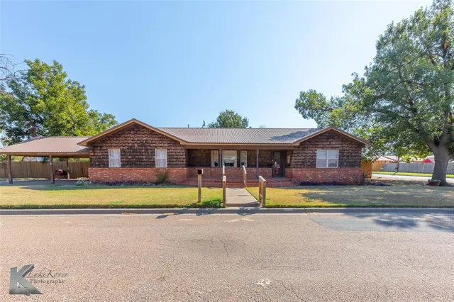 a view of house with outdoor space and swimming pool