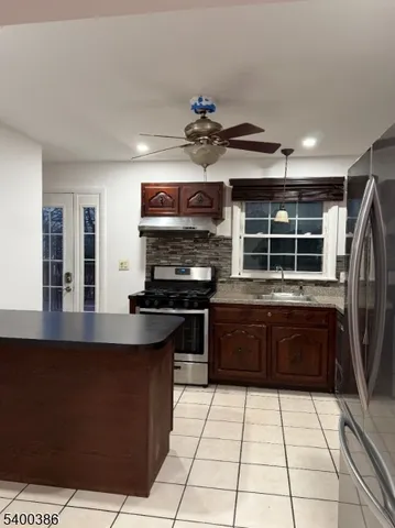 a kitchen with stainless steel appliances granite countertop a stove a sink and a refrigerator