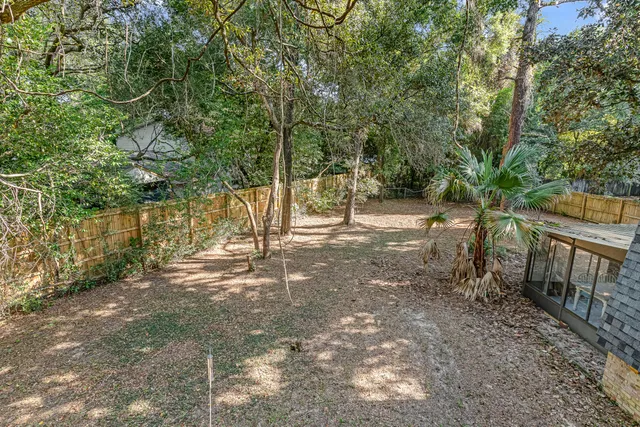 a view of a house with a yard and large tree
