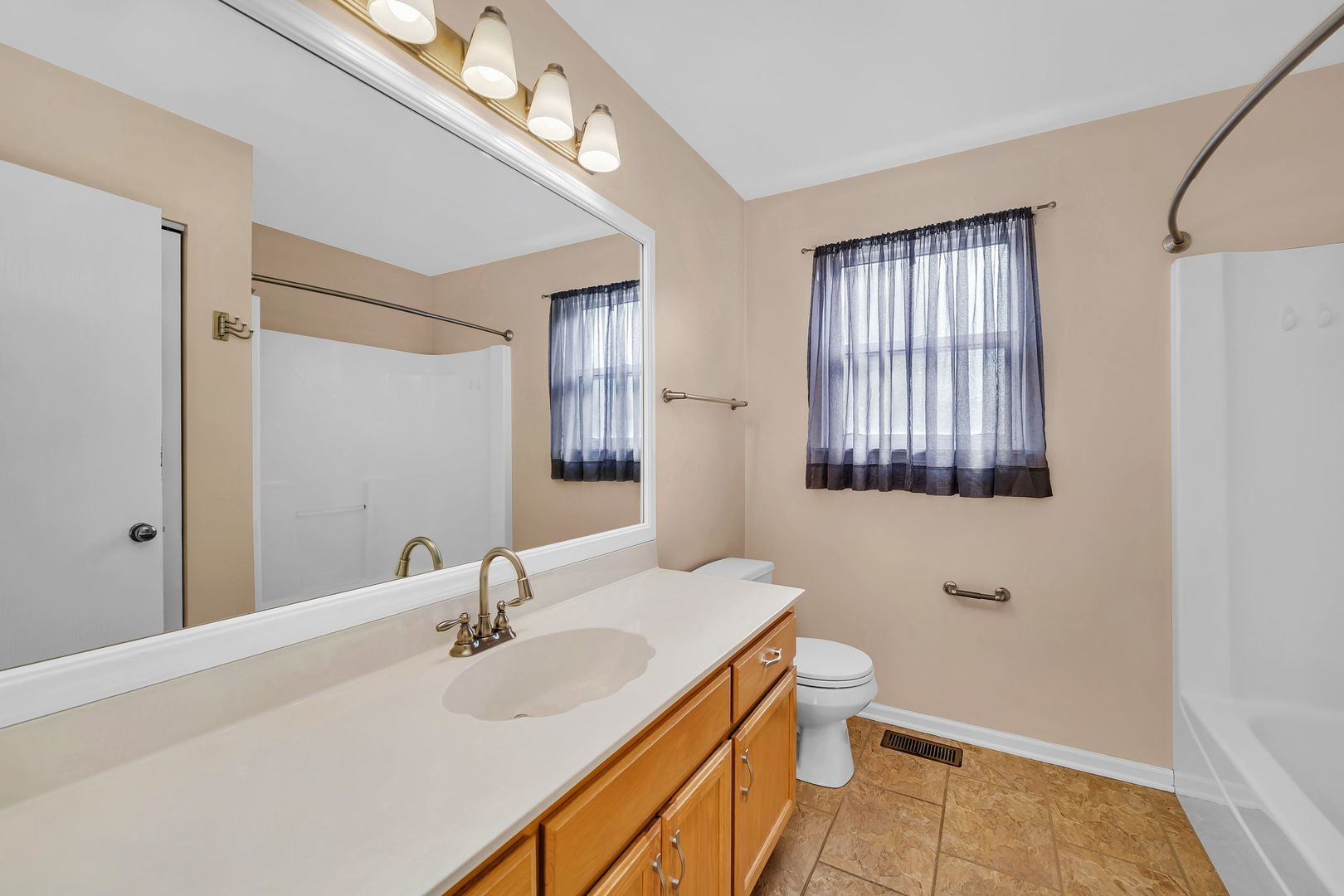 1211 Bluejay Lane Plainfield, IL 60586 - Photo 19 of 32 a bathroom with a sink a toilet and a mirror