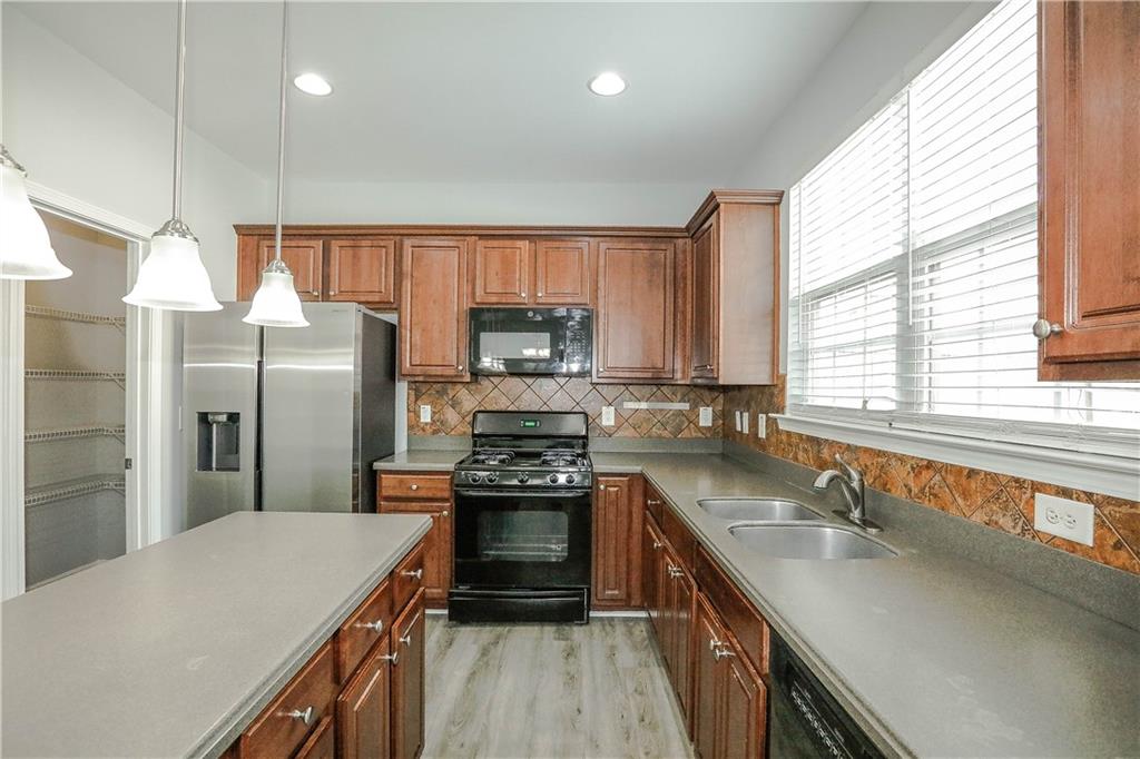 2410 Sardis Chase Court Buford, GA 30519 - Photo 11 of 35 a kitchen with stainless steel appliances granite countertop a sink stove and refrigerator