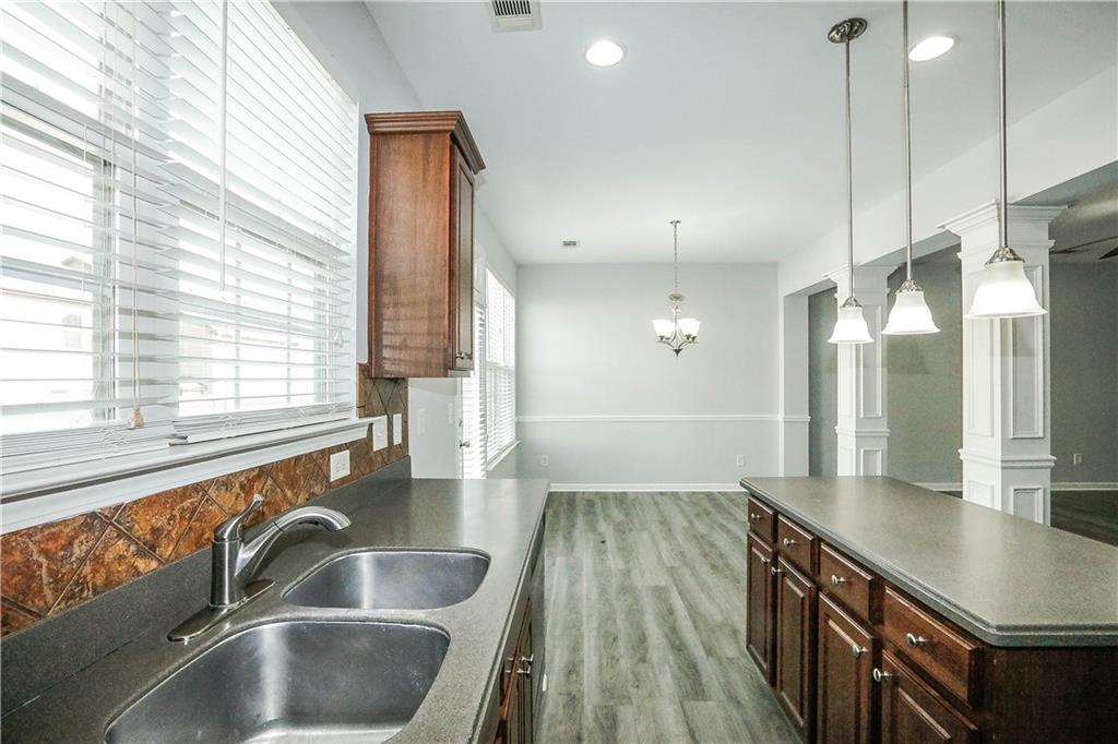 2410 Sardis Chase Court Buford, GA 30519 - Photo 12 of 35 a kitchen with granite countertop a sink and a wooden floor