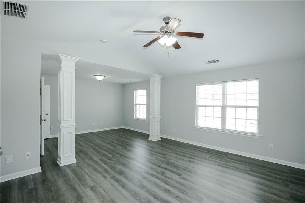 2410 Sardis Chase Court Buford, GA 30519 - Photo 20 of 35 an empty room with wooden floor chandelier fan and windows