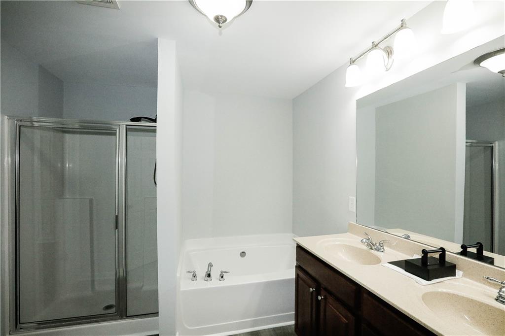 2410 Sardis Chase Court Buford, GA 30519 - Photo 21 of 35 a bathroom with a tub sink vanity granite and shower