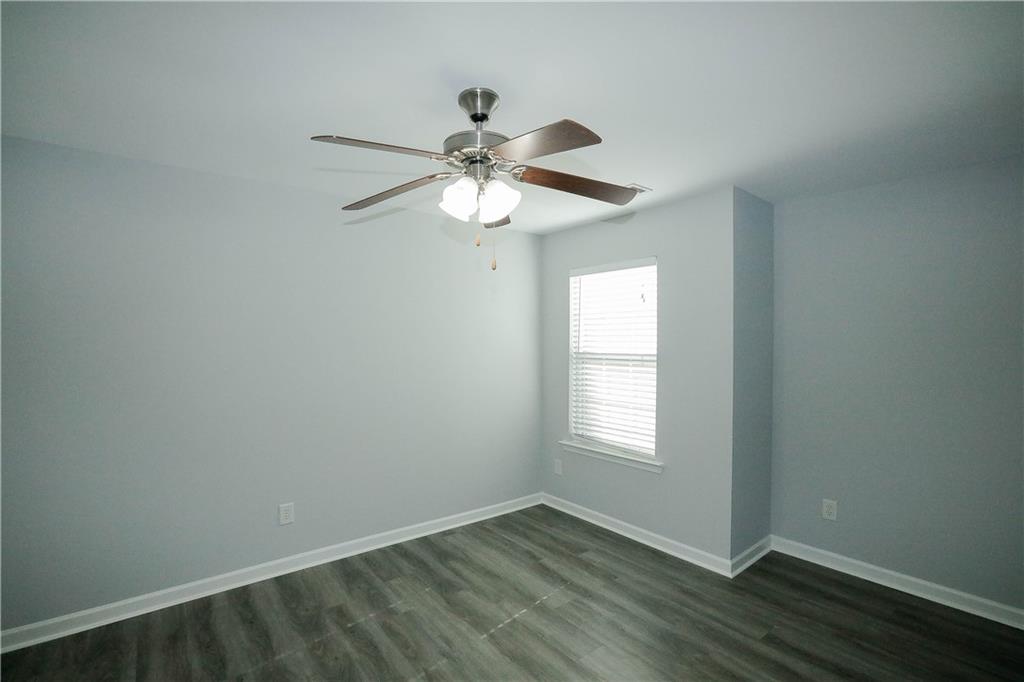 2410 Sardis Chase Court Buford, GA 30519 - Photo 24 of 35 an empty room with wooden floor chandelier fan and windows