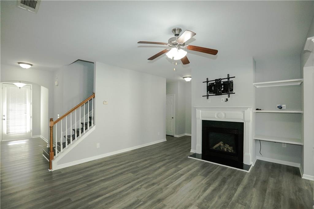 2410 Sardis Chase Court Buford, GA 30519 - Photo 4 of 35 a view of an empty room with wooden floor fireplace and a window
